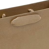 Close-up of a medium brown paper bag with sturdy ribbon handles from Prime Line Packaging, made of 120 GSM brown kraft paper.